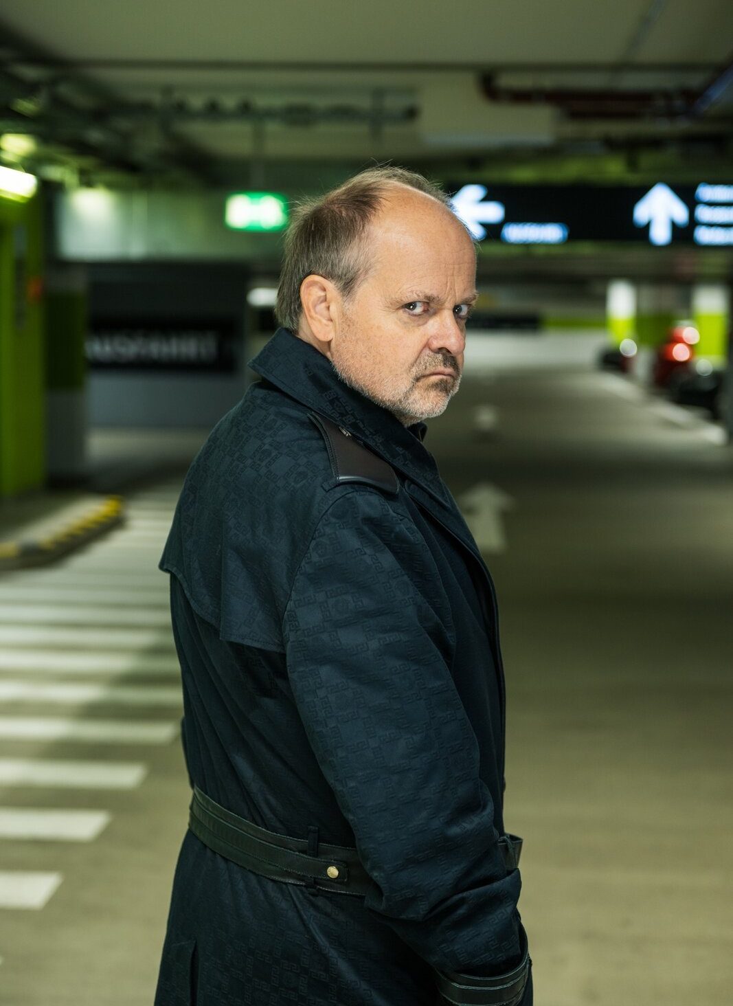Markus Majowski im Mantel in einer Tiefgarage
